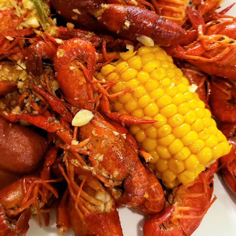 Boiled crawfish with corn on the cob, garlic, and seasoning, a Vietnamese dish.